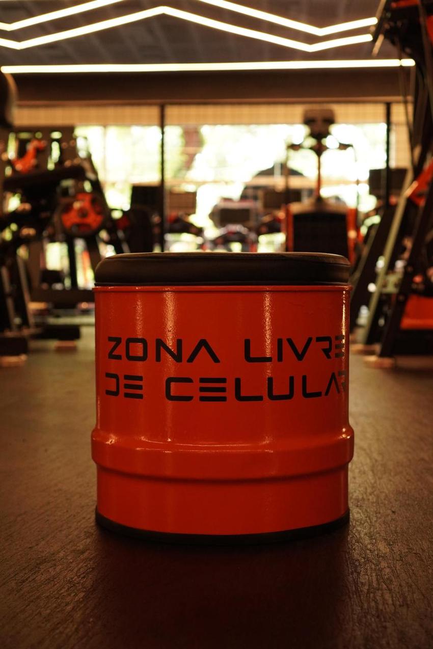 Banquinho laranja em formato de tambor com a frase "zona livre de celular" impressa na lateral